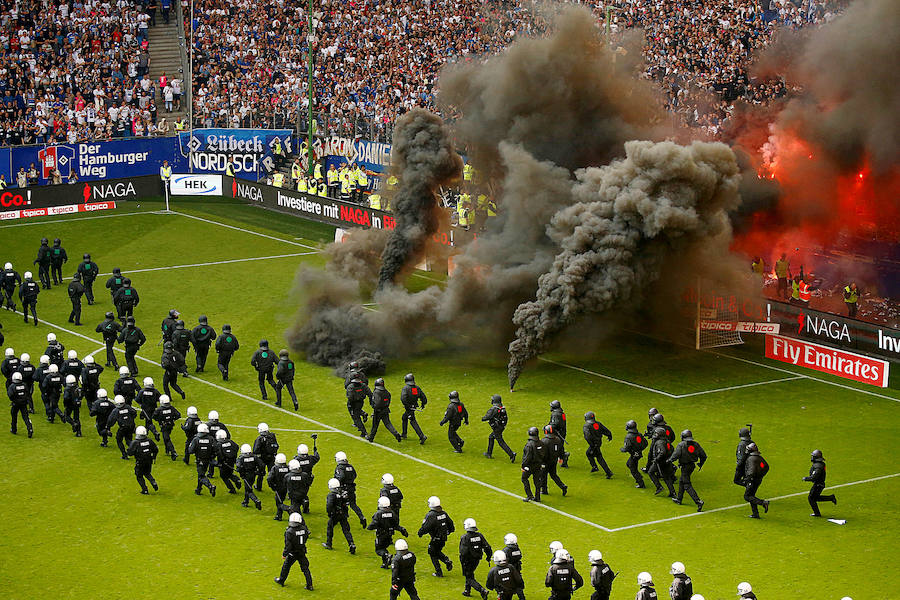 Seguidores del Hamburgo y miembros de la Policía se enfrentan durante un partido de la Bundesliga. 