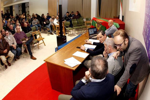 El presidente de la Gimnástica habla con directivos del club durante la última asamblea de socios de la entidad.