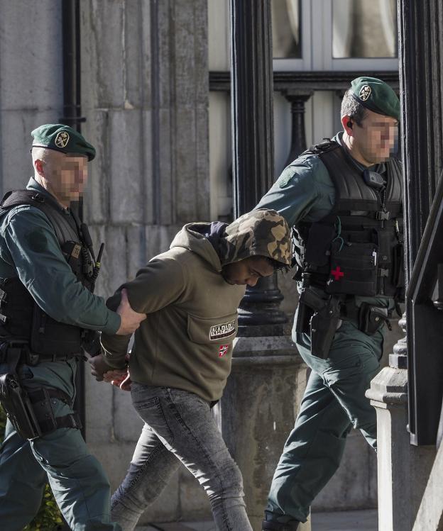 Dos agentes de la Guardia Civil custodian al asesino confeso durante su entrada en los juzgados de Laredo.