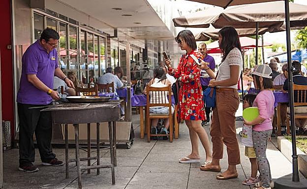Turistas chinas fotografían a un cocinero del Barrio Pesquero de Santander.