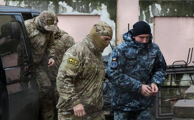 Miembros del Servicio Federal de Seguridad ruso conducen a uno de los marineros ucranianos detenidos.