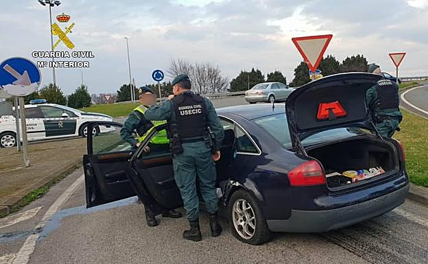Agentes de la USECIC registran el vehículo del detenido.