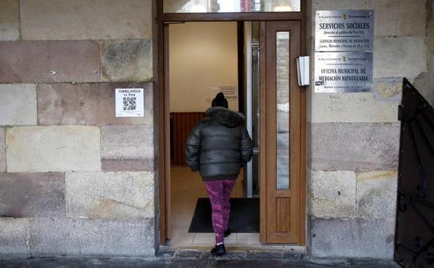 Una mujer accede a la oficina de Servicios Sociales de la plaza Baldomero Iglesias.