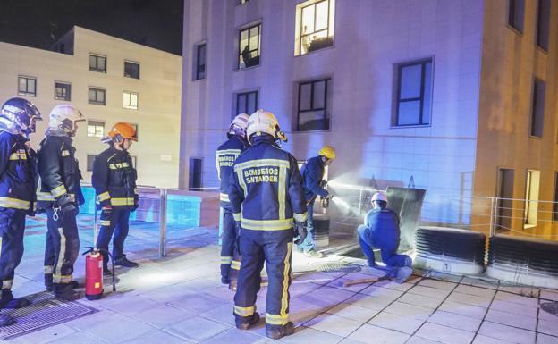 Bomberos y empleados de la compañía eléctrica revisan el transformador. :: 