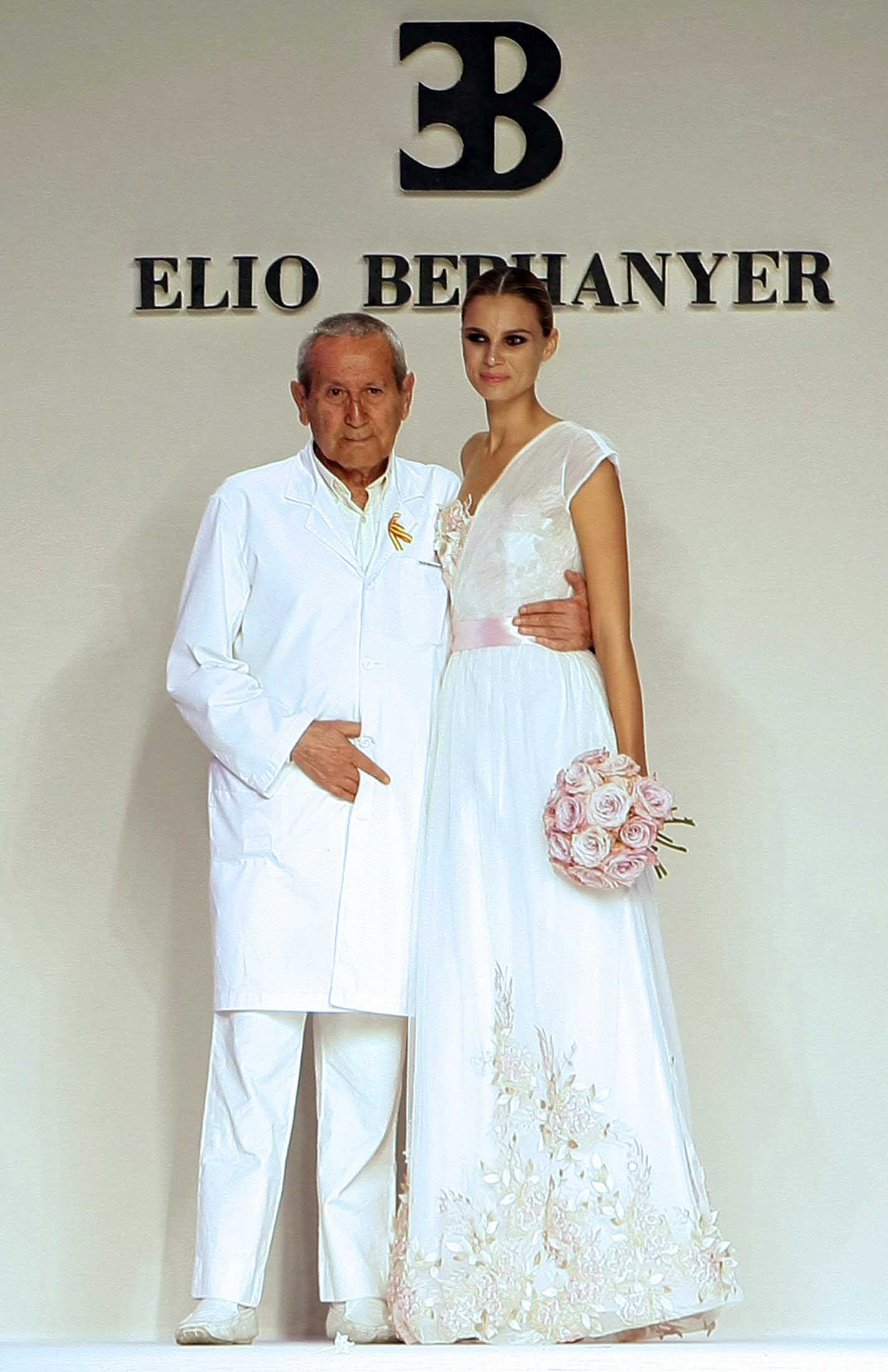 Elio Berhanyer, diseñador español, junto a una modelo, saluda al público tras presentar su colección otoño-invierno 2009 en la Pasarela Cibeles.