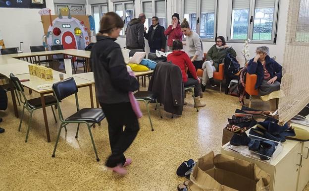 Los vecinos de Santa Olalla esperan en el colegio de La Serna después de ser evacuados.