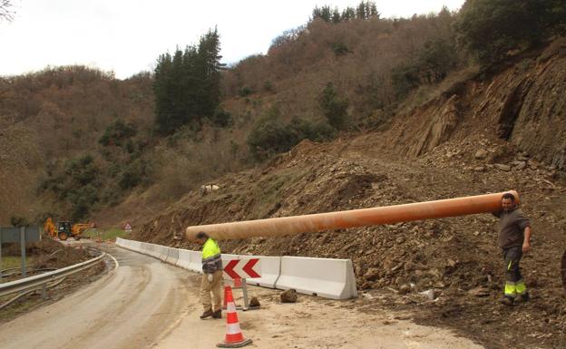 Imagen. Dos de los operarios que han trabajado en la carretera que une Potes con Fuente Dé, donde ayer cayó un argayo que rompió una tubería general.