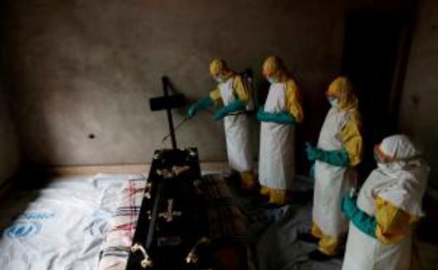 Personal sanitario desinfecta un ataúd para evitar la propagación del ébola en Congo.
