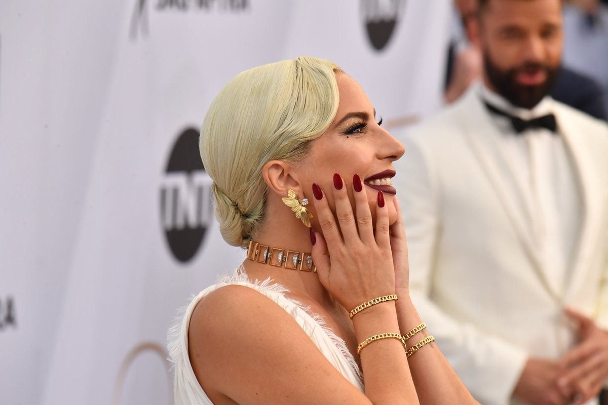 Vestida de blanco con un gran corte en la falda y un pronunciado escote. La pieza está firmada por Dior Alta Costura. 