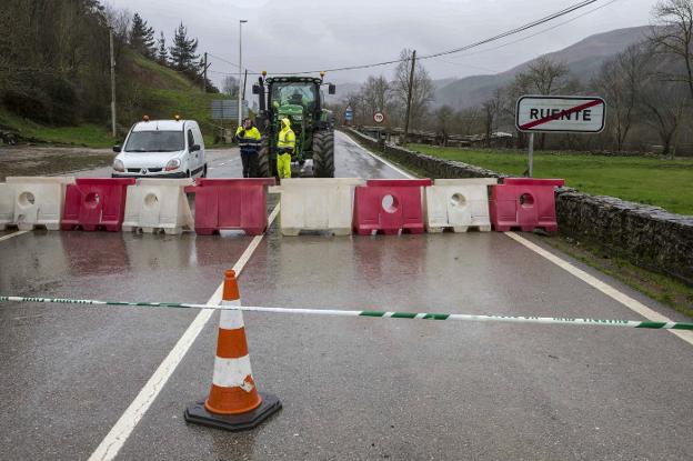 Dos operarios controlan el acceso al argayo de Ruente, en la CA-180, donde ayer se realizaron sondeos para encontrar una solución. 