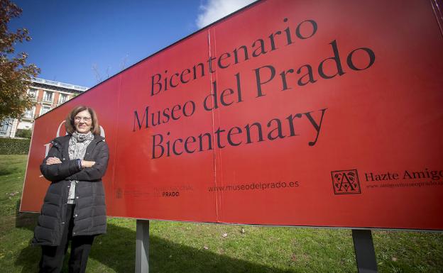 Nuria de Miguel junto a un cartel del bicentenario del Prado. 