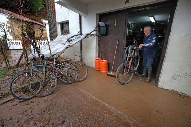 Un vecino de Virgen de la Peña, una de las localidades más afectadas, retira bicicletas y enseres del bajo de su vivienda después de las inundaciones de enero.