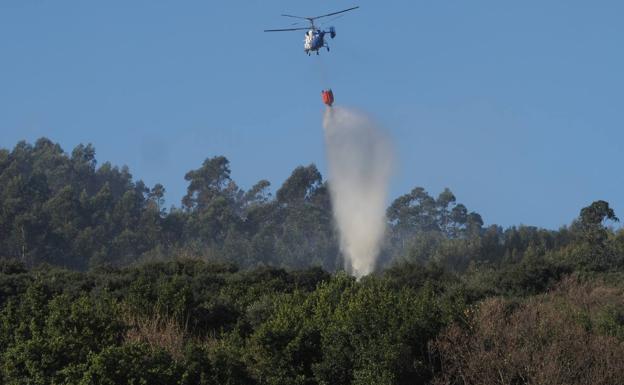 El helicóptero del Ministerio de Agricultura, interviniendo esta mañana en el incendio de Castro Urdiales, que ya está extinguido, aunque está siendo vigilado.