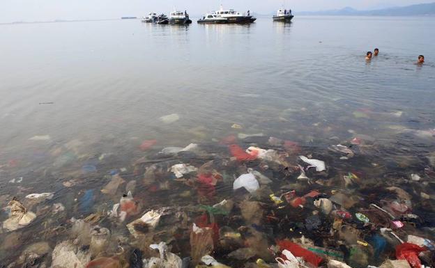 Residuos plásticos sumergidos en el agua en la bahía de Lampung.