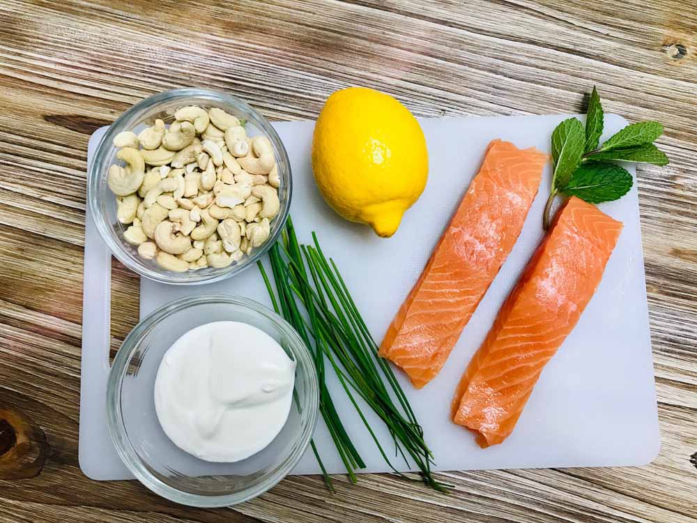 Tartar de salmón. Ingredientes: 250 gramos de salmón noruego sin piel y sin espinas; 125 gramos de anacardo natural; Cebollino (al gusto); Pimienta negra (al gusto); Aceite de oliva virgen 3 cucharadas; Medio limón exprimido; Sal (al gusto). Para la salsa de yogur: Yogur natural 0% materia grasa; Menta; Aceite de oliva virgen; Sal. 