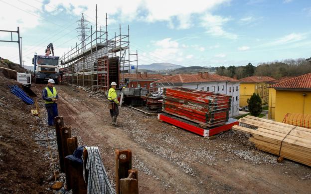  Frente a frente. Dos operarios trabajan en la obra del nudo de Torrelavega, a pocos metros de las casas. 