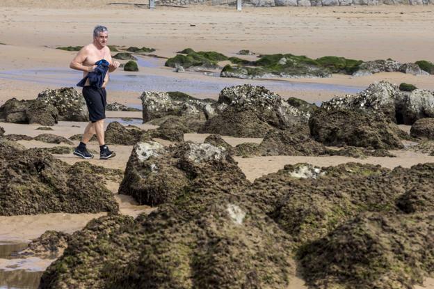 Un hombre pasea por la playa de La Magdalena, donde ayer se apreciaba el efecto de una marea baja de gran coeficiente. 