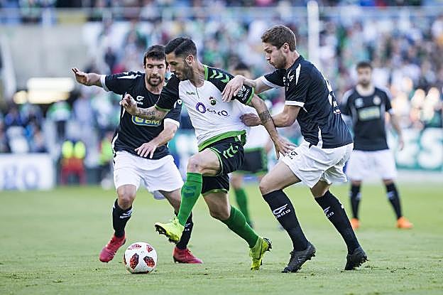 Cejudo avanza ante el acoso de dos jugadores del Real Unión. 