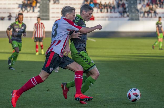 Sergio Ruiz protege el balón ante la presión de Rojo. 