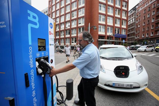 Un conductor utiliza un punto de recarga para vehículos eléctricos. :