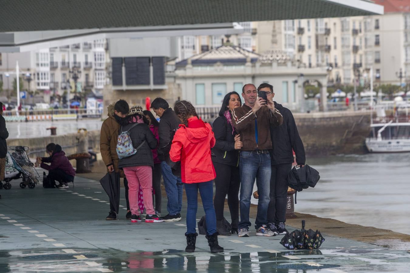 Imágenes de turistas paseando por Santander este lluvioso Jueves Santo