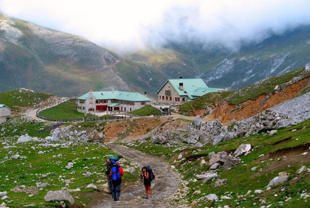 Tres montañeros llegan al Refugio de Áliva. 