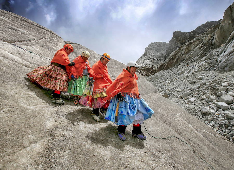 Hace tres años once mujeres indígenas aymaras de entre 22 y 50 años que trabajaban como portadoras ycocineras para montañeros en los campos base y montañismo de Bolivia se unieron para escalar cimasvestidas con su atuendo tradicional para demostrar a quienes no confiaban e ellas que podían llegar a lascumbres. En la imagen, practican el descenso de un glaciar en la montaña Huayna Potosí, situada en elnoroeste de Bolivia, a 25 km de La Paz, provistas de crampones, unos de los materiales de alpinismo yescalada indispensables para poder avanzar por los terrenos helados. Esta cima se alza monolíticamenteentre roca, hielo y nieve hasta los 6.088 metros de altitud.