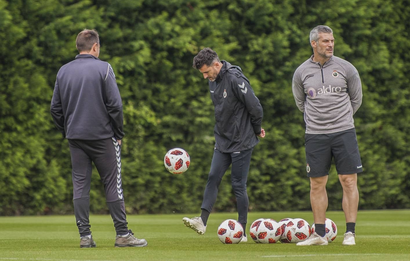 Iván Ania juega con un balón, durante un entrenamiento de esta semana, junto a sus técnicos.