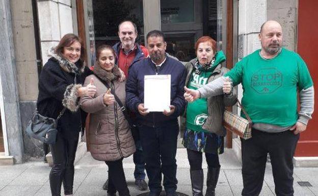 Varios miembros de la PAH posan junto a José (centro) y su mujer (segunda por la izquierda), que iban a ser desahuciados de su vivienda en Boo de Guarnizo.