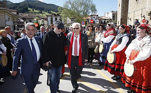 Revilla acompaña a Silvio Rodríguez y al padre Ángel al Centro de Estudios Lebaniegos en medio del pasillo formado por el Colectivo Etnográfico Brañaflor. 