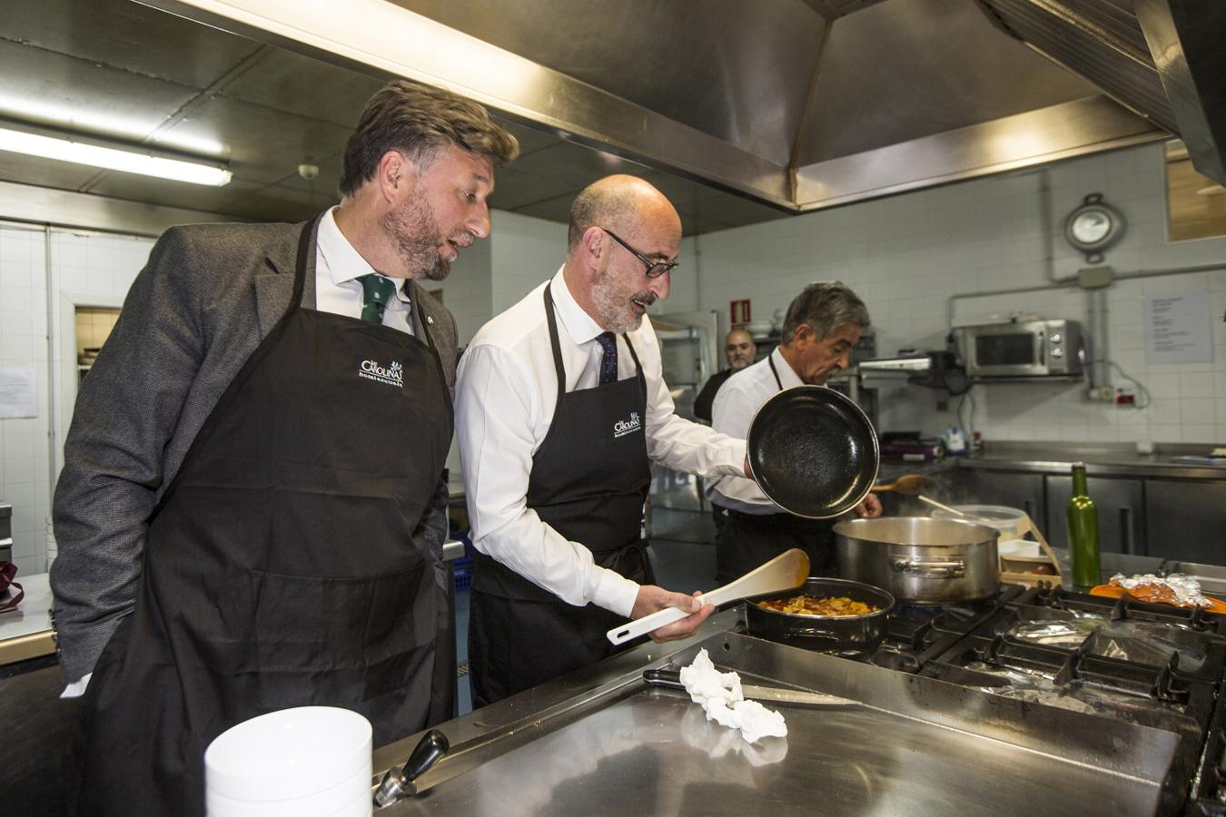 Félix Álvarez muestra sus patatas con cachón a Cristóbal Palacio mientras Revilla, al fondo, prepara su revuelto de perrechicosl.