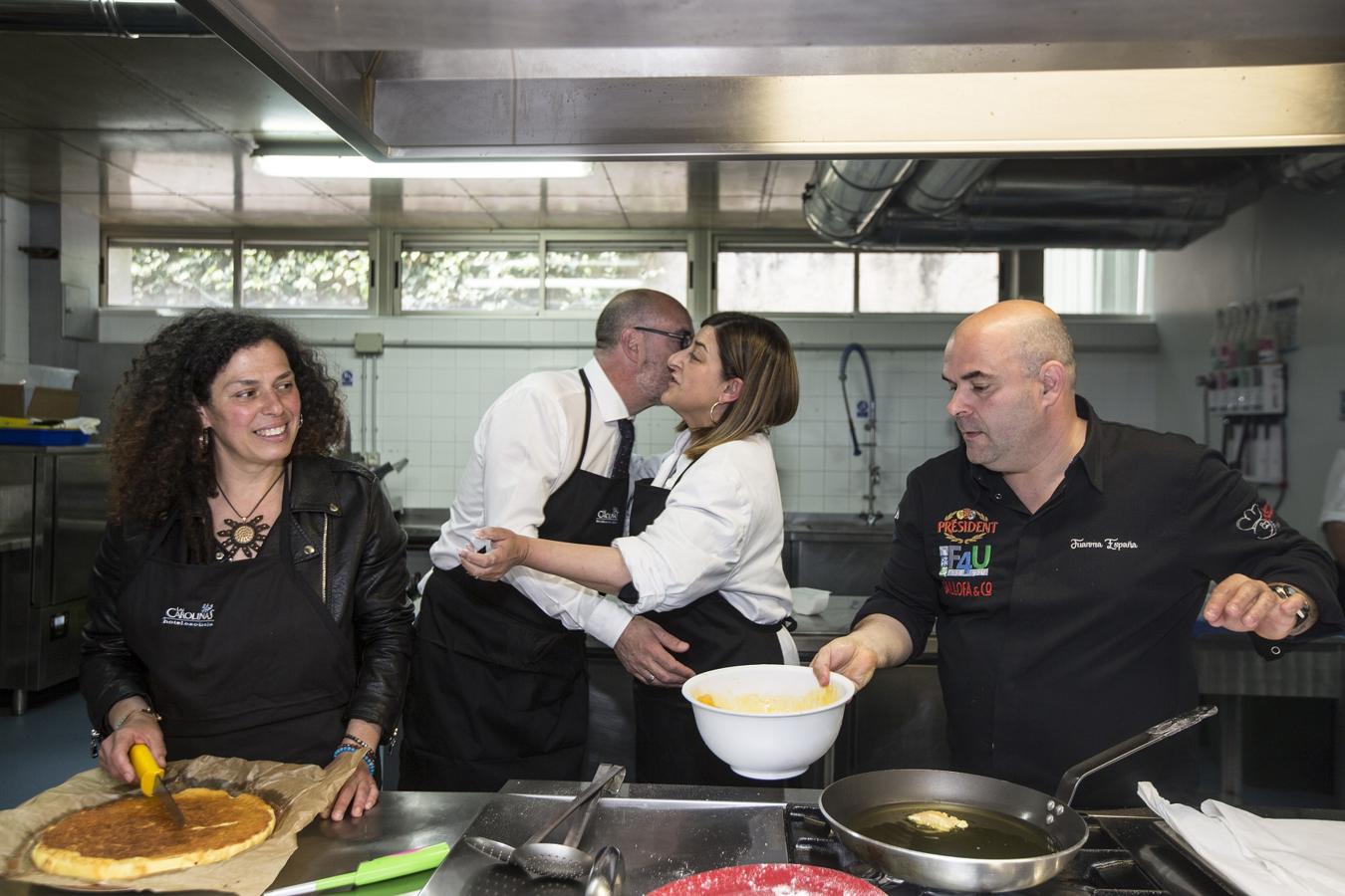 Félix Álvarez saluda a María José Sáenz de Buruaga mientras Mónica Rodero corta su quesada casera.