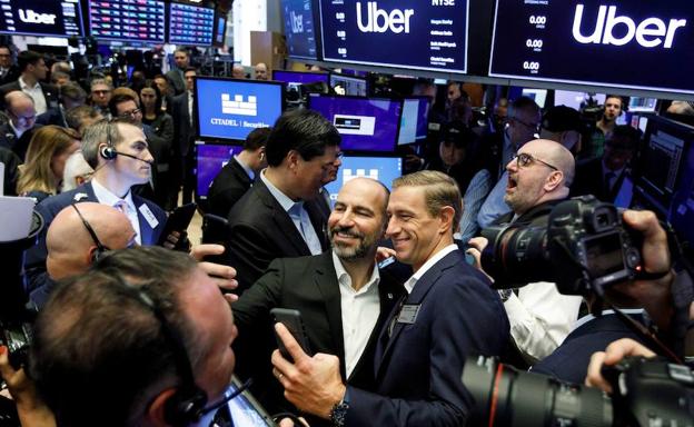 El director ejecutivo de Uber, Dara Khosrowshahi (c), junto a uno de sus cofundadores durante la salida a bolsa de la empresa.