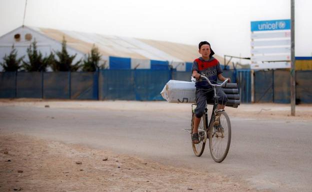 Un joven circula en bicicleta en un campo de refugiados de Jordania. 