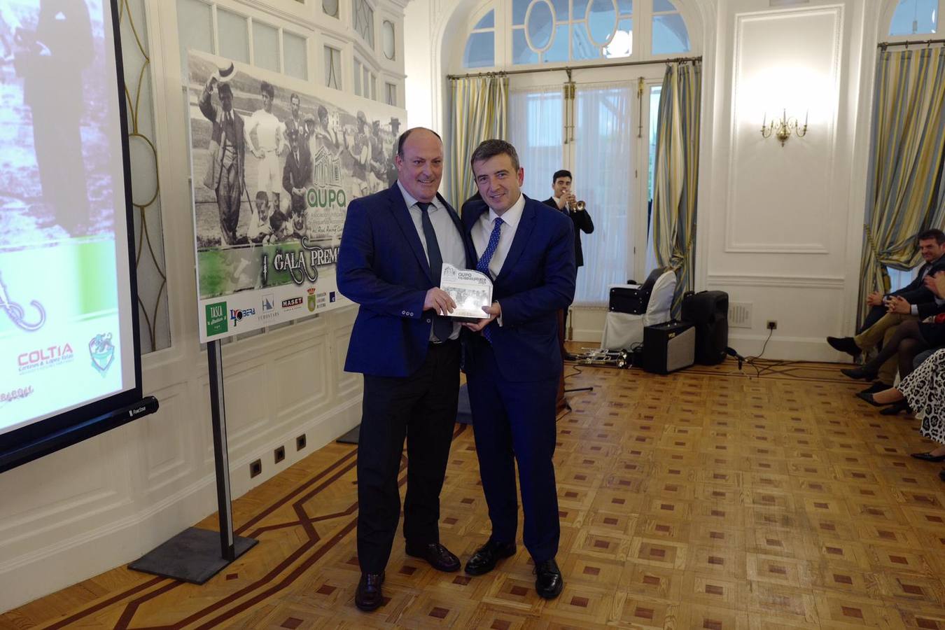 El exconsejero del Racing Juanjo Uriel recibe el premios de manos del actual consejero David Gónzalez Pescador.