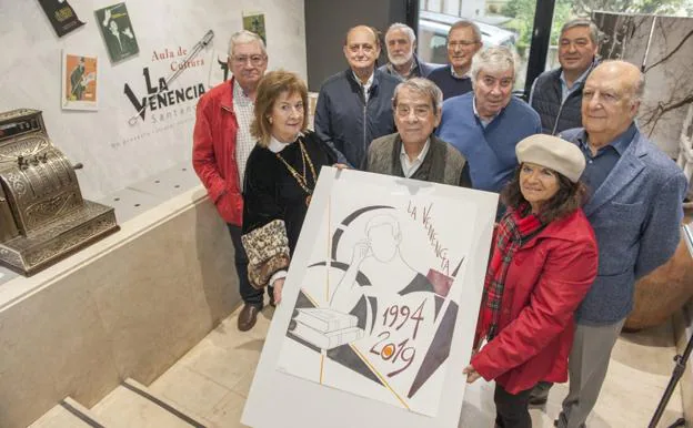 Miembros de La Venencia posan junto con un cartel conmemorativo del aniversario realizado por Pedro Sobrado.
