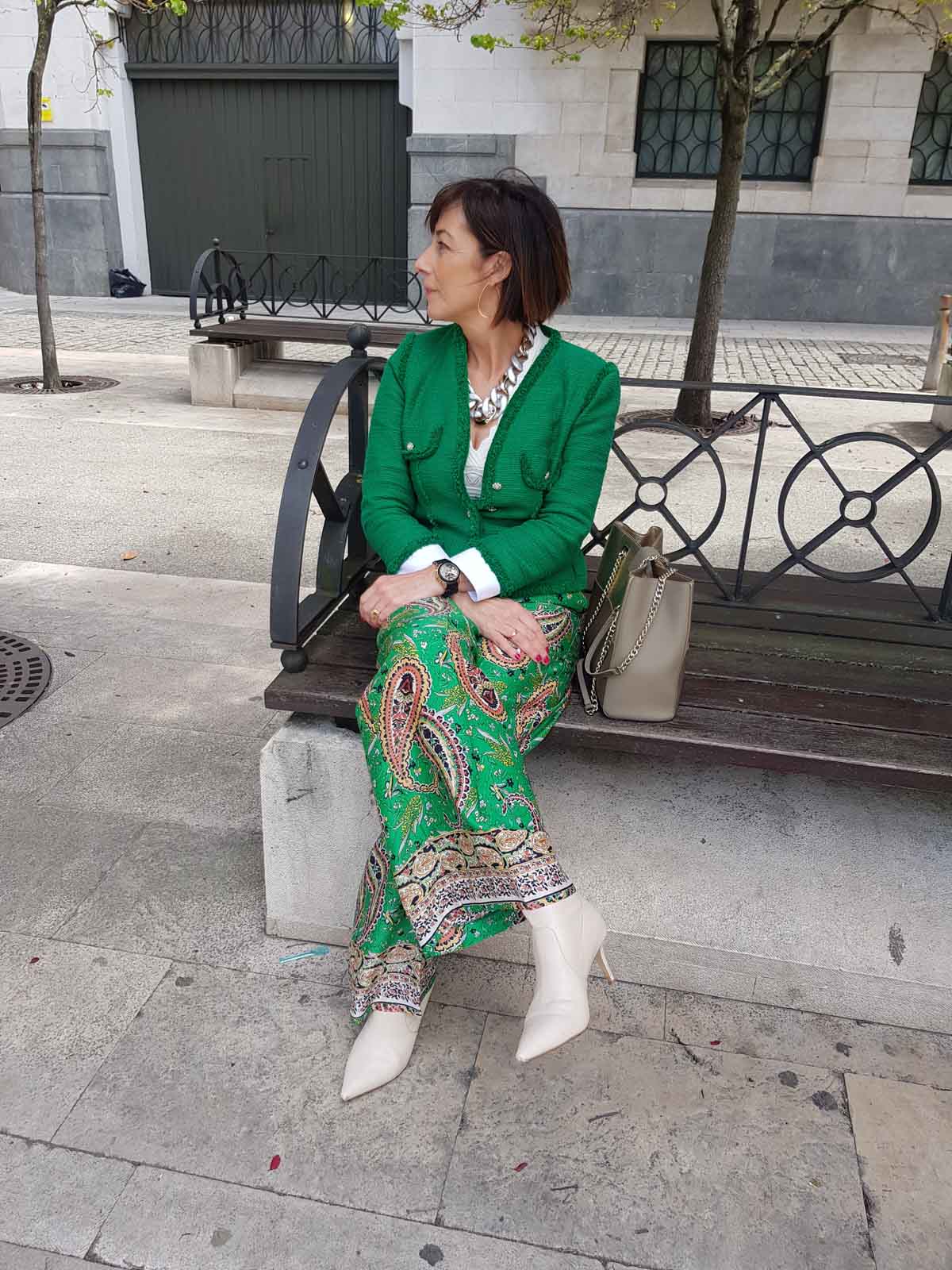 Un estilismo formado por un pantalón extra ancho de estampado de cachemire y tejido sedoso acompañado de la eterna chaqueta de 'tweed' (estilo Chanel) en verde. 