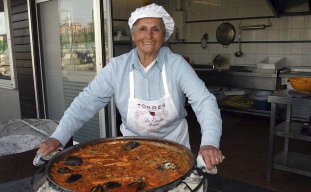 La Chola, en su Barrio Pesquero, con una de sus míticas paellas.