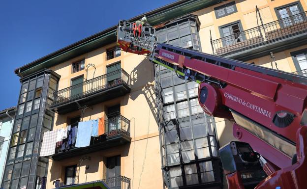 Los bomberos retiran parte de los elementos que se pueden desprender.