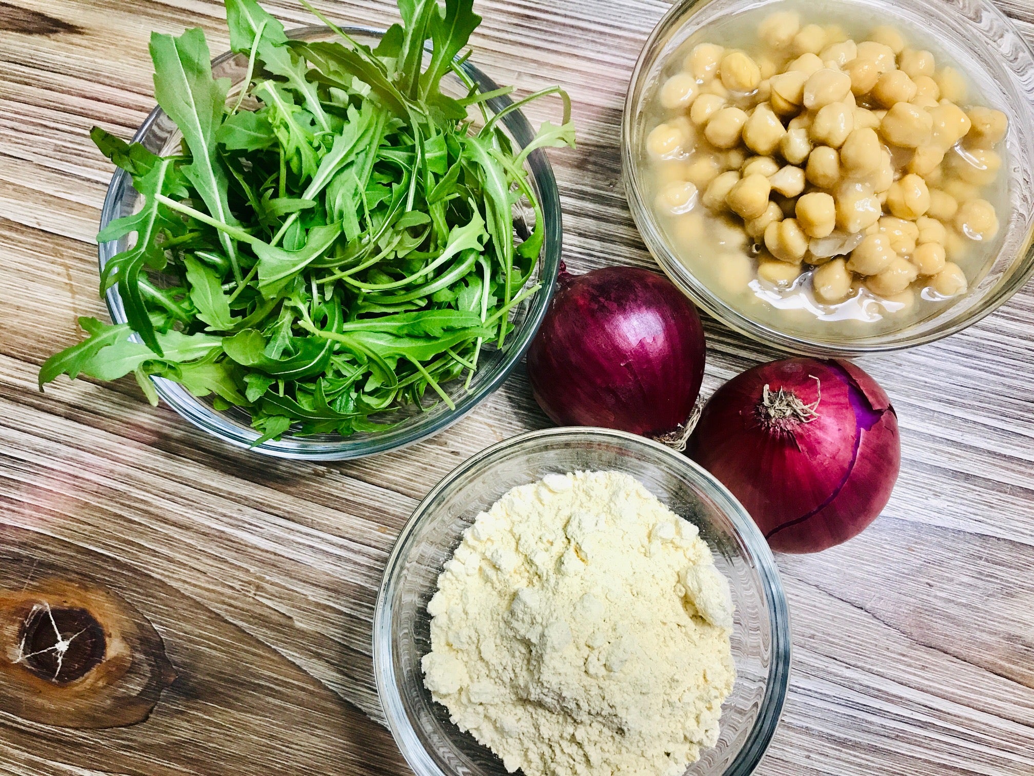 PIZZA DE GARBANZOS. Ingredientes: 300 gramos de harina de garbanzos; 200 mililitros de agua tibia; Sal; ½; Levadura de panadero Royal; Cebollino (opcional). Para el relleno: Garbanzos cocidos; Rúcula; Cebolleta roja; Sal; Aceite de oliva virgen y crema de vinagre de Módena. 