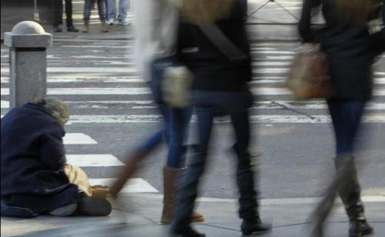 Una persona pide dinero en la calle.