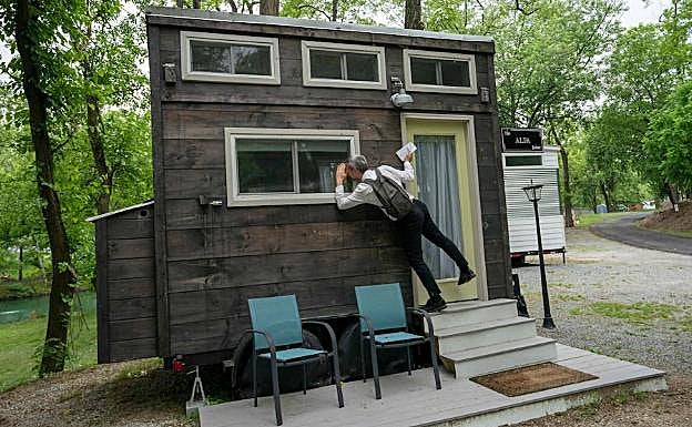 Un reportero curiosea el interior del modelo 'Alfa' de minicasa en la feria de Pensilvania