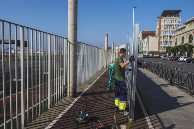 Los operarios trabajan en el inicio de las obras para la sustitución de la valla portuaria en la calle Antonio López. 