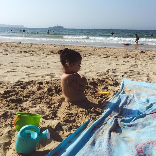 La pequeña India, algo enfadada, disfruta de un tiempo de juegos en la playa.