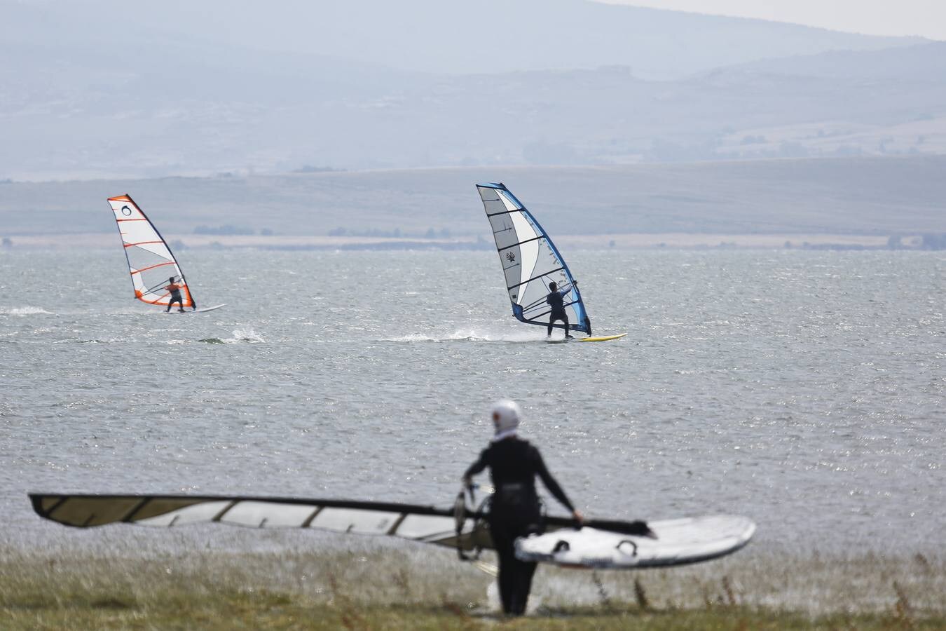 El viento permite a los windsurfistas deslizarse a toda velocidad por el agua.