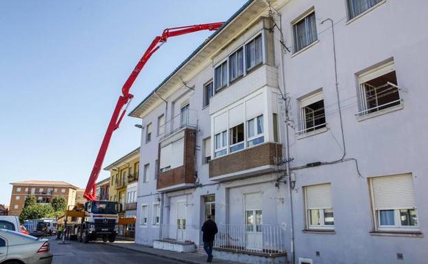 Un camión con un brazo articulado trabaja junto a las casas del barrio La Palmera, las más próximas a las obras. 