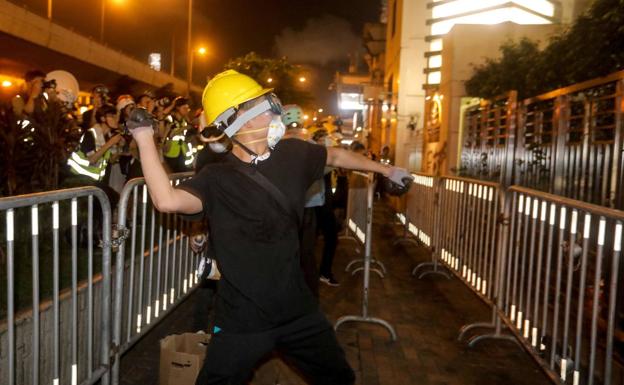 Un joven lanza un objeto contra la Oficina de China, en Hong Kong.