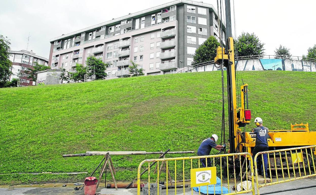 Dos operarios realizan mediciones en el lugar donde está prevista la construcción del elevador. 