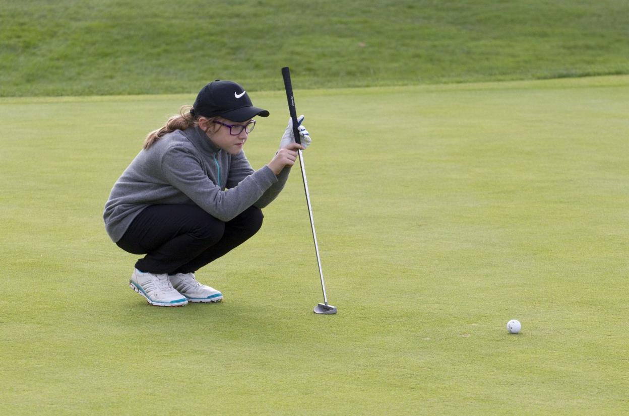 Una jugadora mira la bola en uno de los greens de Pedreña en la edición de 2018 del Gran Premio de Golf de El Diario Montañés. 