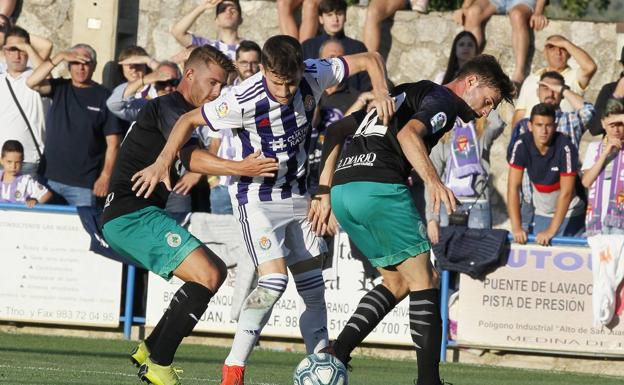 Los racinguistas Carmona y Cayarga pugnan por recuperar el balón ante un rival vallisoletano en el partido de ayer en Medina de Rioseco (Valladolid)